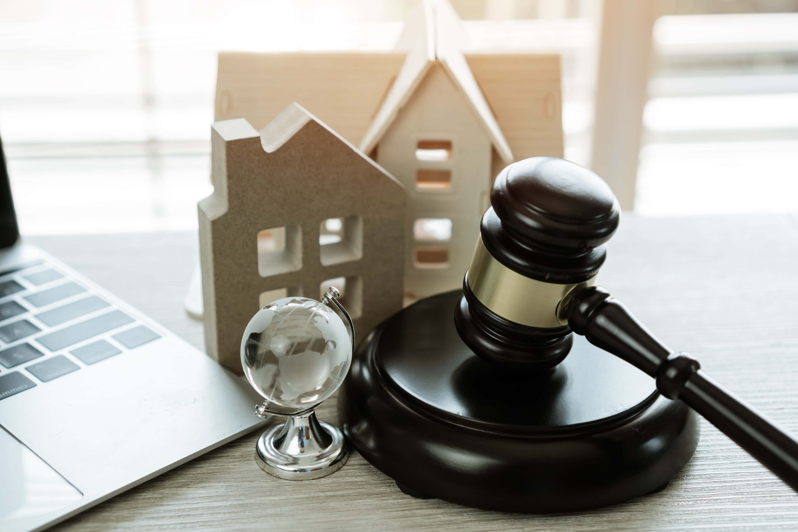 Judge's gavel alongside a model house, symbolizing legal decisions related to identity theft and potential impacts on property or financial issues