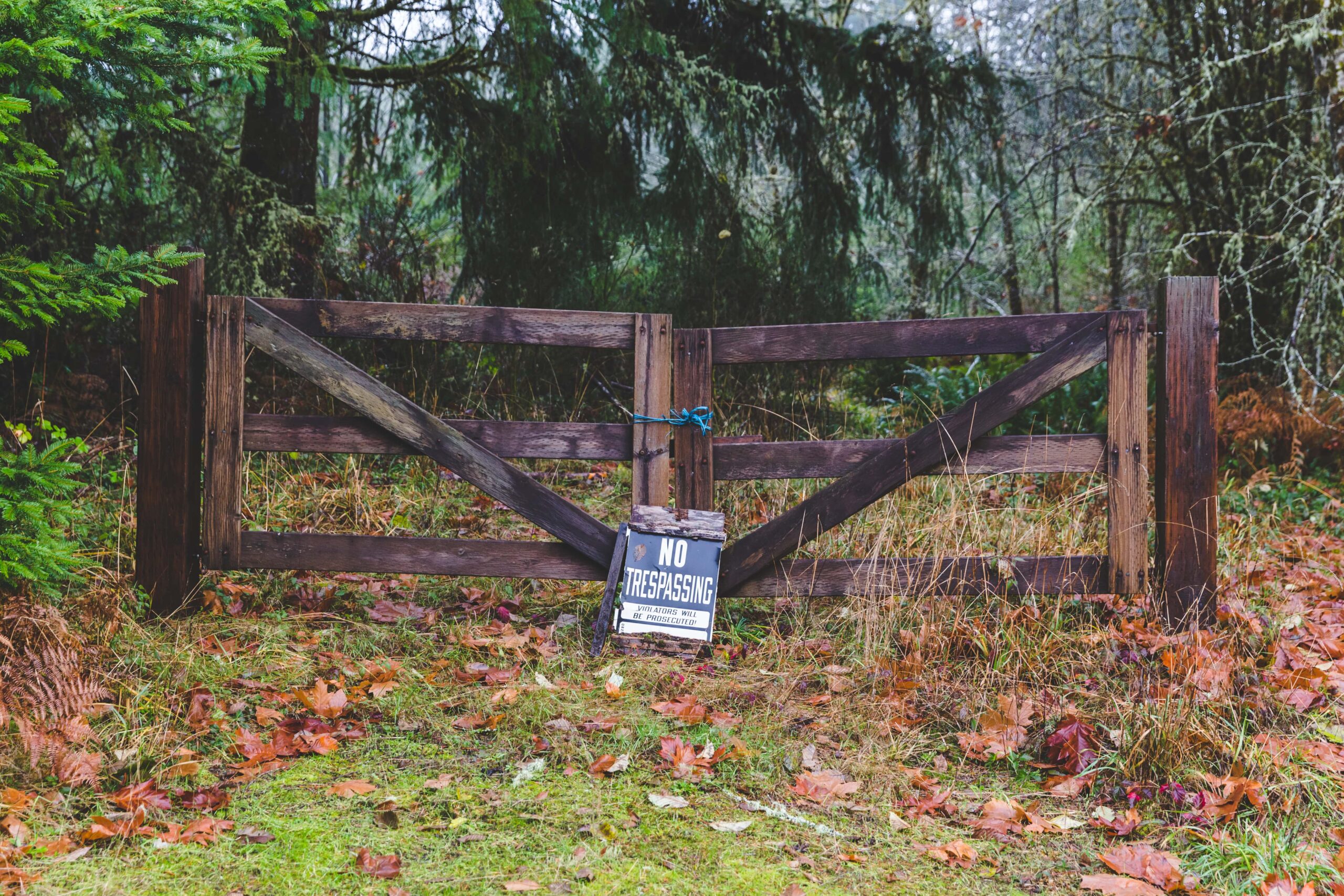 No Trespassing sign posted on a wooden gate, representing property boundaries and potential legal issues