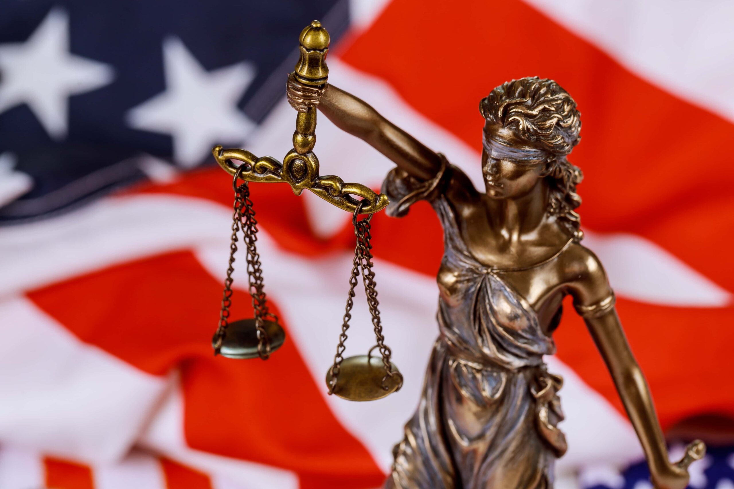Statue of Lady Justice with USA flag in the background, symbolizing justice and legal defense by a Brookhaven criminal lawyer in the United States