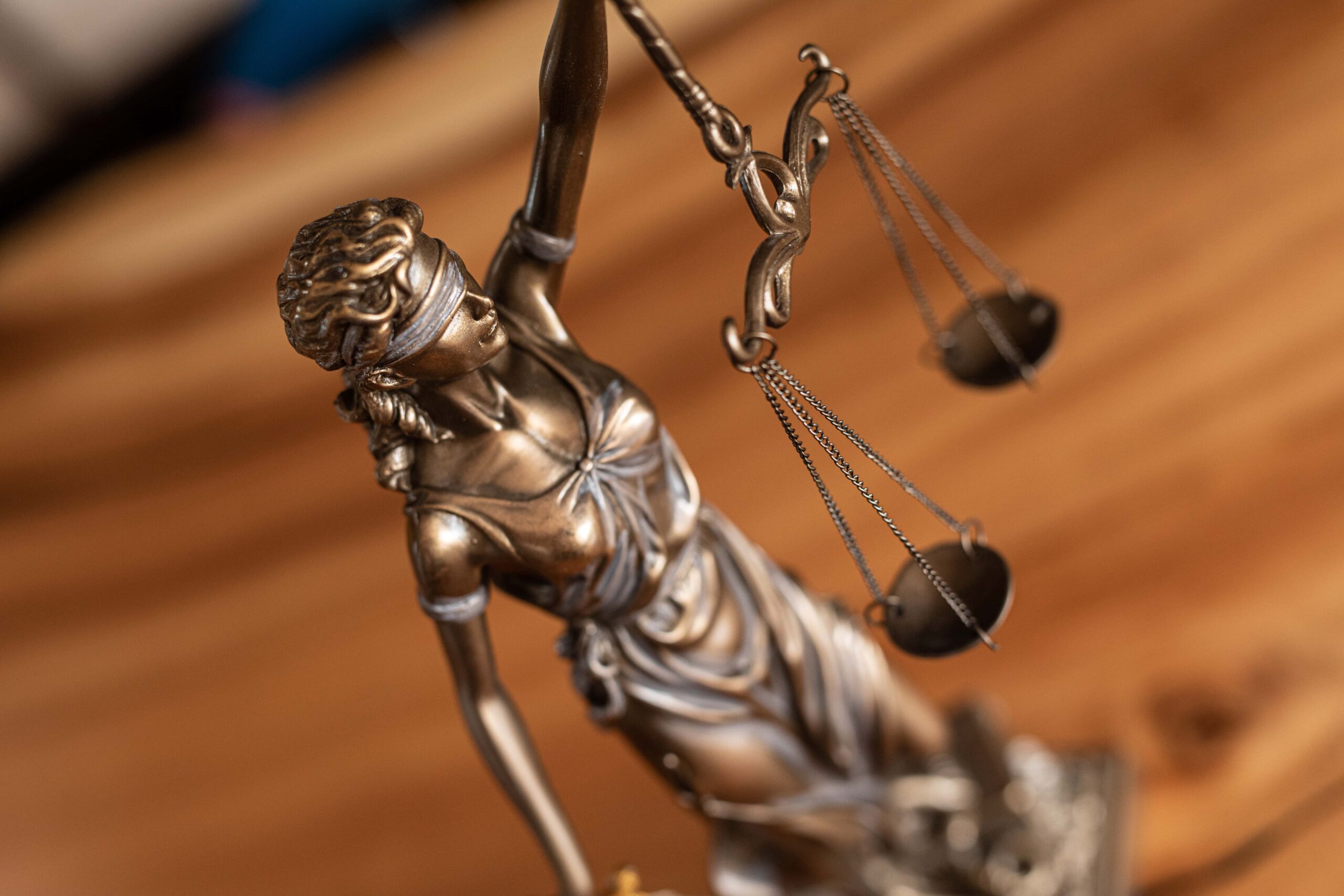 Statue of Lady Justice placed on a desk, symbolizing law and fairness