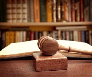 Wooden gavel resting beside an open law book, symbolizing the legal arguments and decisions involved in pretrial suppression hearings