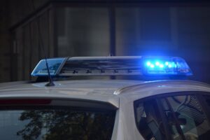 Flashing police lights during a traffic stop, symbolizing the legal consequences and fines associated with speeding violations