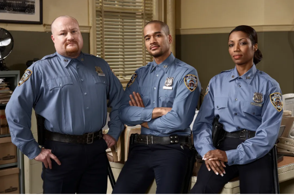 Three uniformed police officers in Nassau County, with the central officer standing confidently arms folded, representing the good, bad, and ugly sides of police body camera evidence in criminal cases