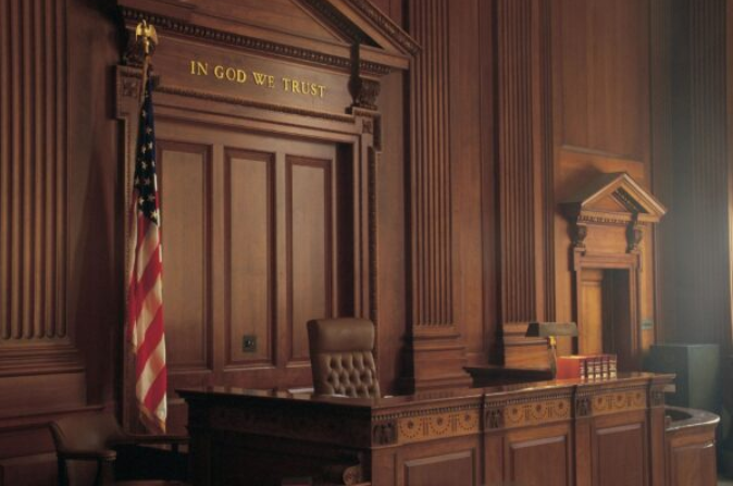Empty courtroom with 'In God We Trust' engraved above judge's bench, symbolizing Long Island village court defense