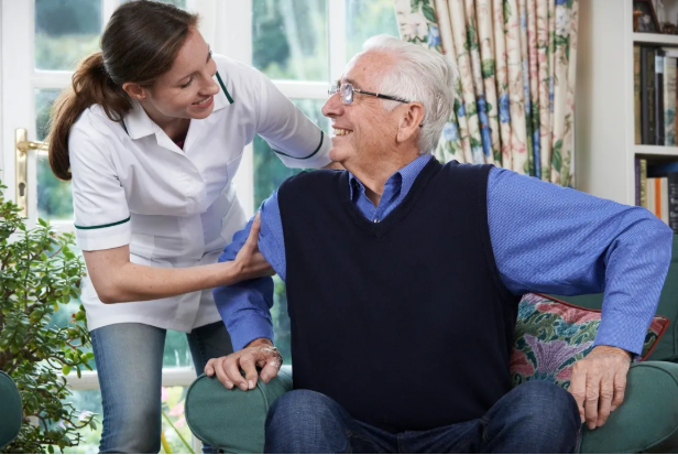 Young female gently helping her grandfather stand, symbolizing how scammers gain trust in elder fraud cases and the need for Long Island grandparent scam defense